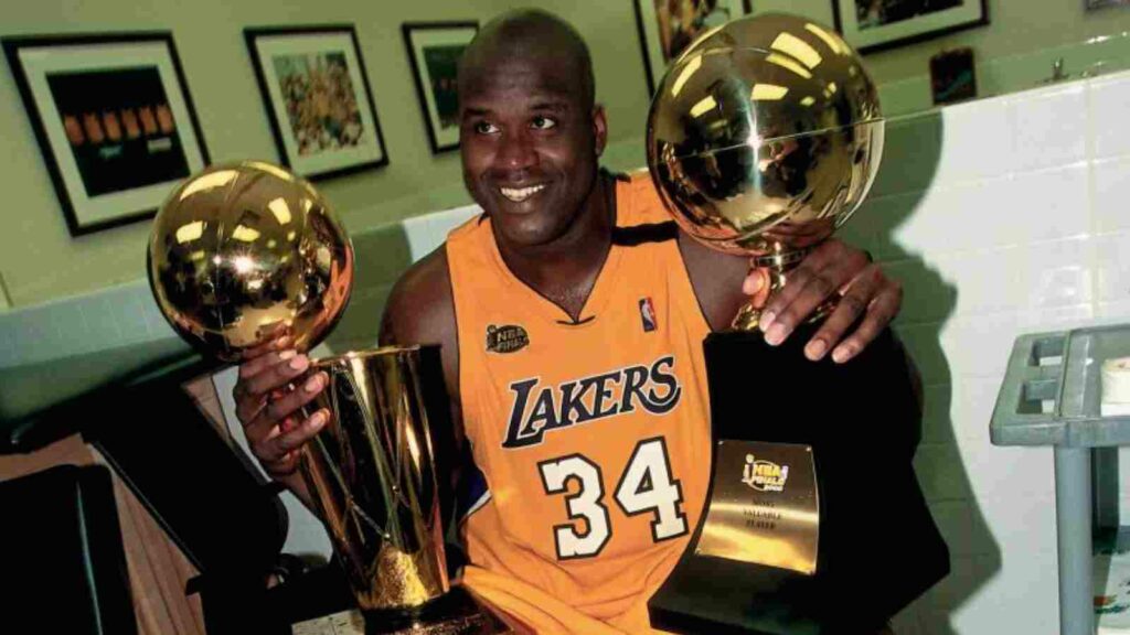 Shaquille O'Neal with the NBA title and the FMVP trophy in 2000