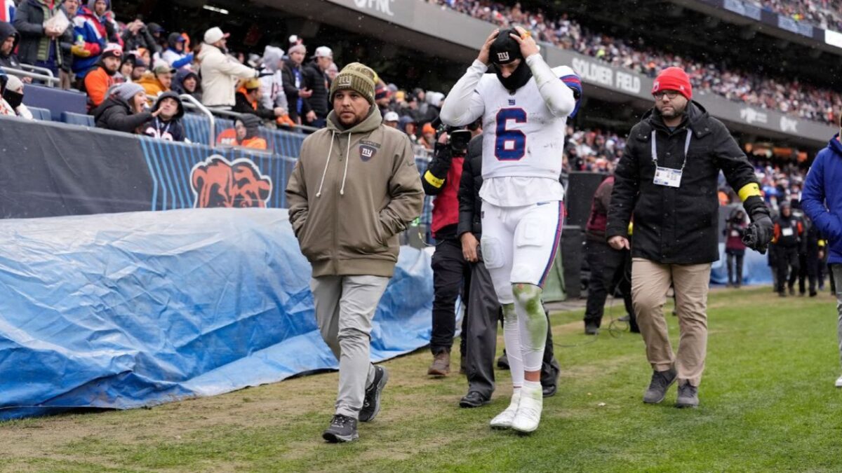 Giants' medical staff escorting Jaxson Dart to medical room