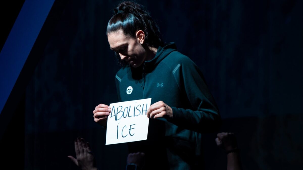 Breanna Stewart holding up the 'ABOLISH ICE' sign